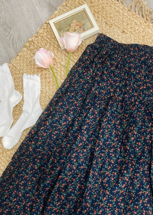 Floral fabric, white socks, and pink flowers on a textured surface