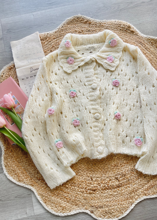 White baby sweater with floral embellishments and crochet 3D flowers