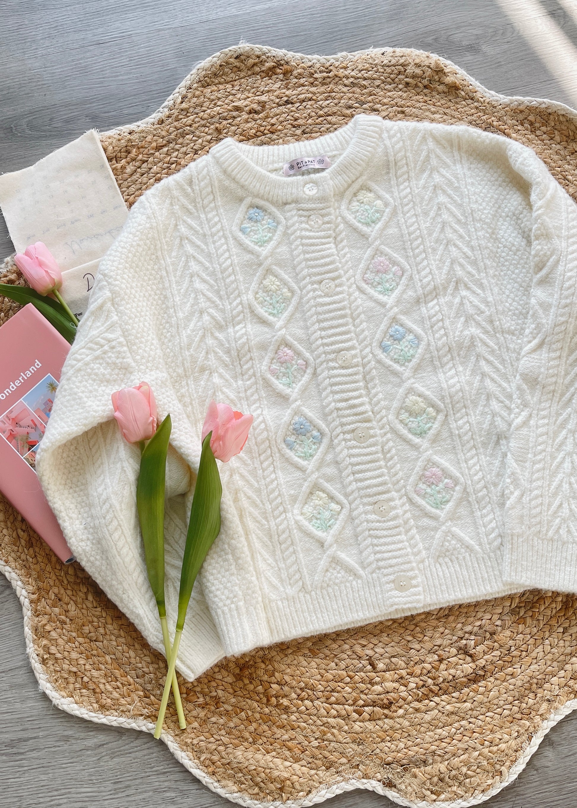 White knitted sweater with crochet flowers.